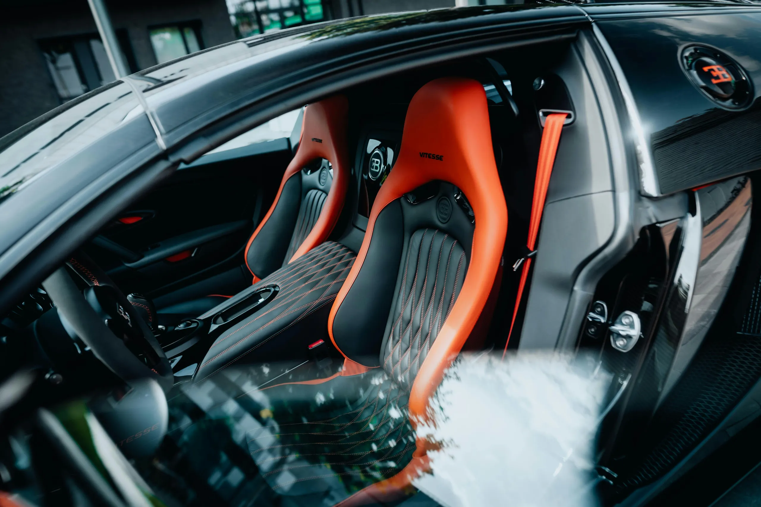 Asientos deportivos naranja y negro de un Bugatti en el interior del coche