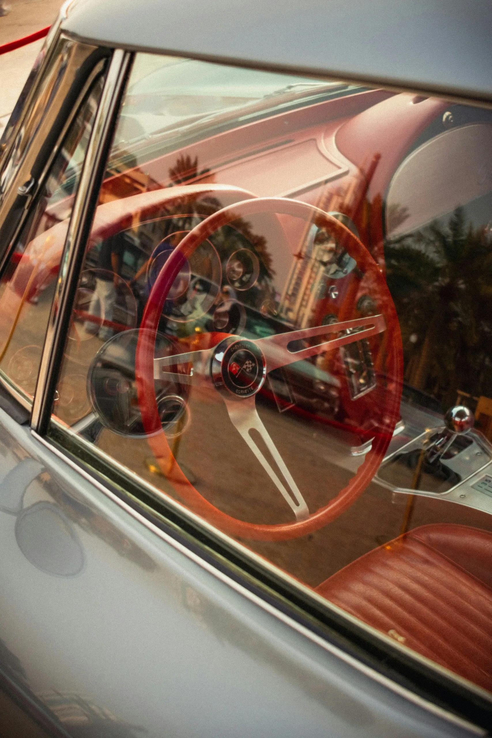 Un clásico con volante de madera, interior reflejado en el cristal